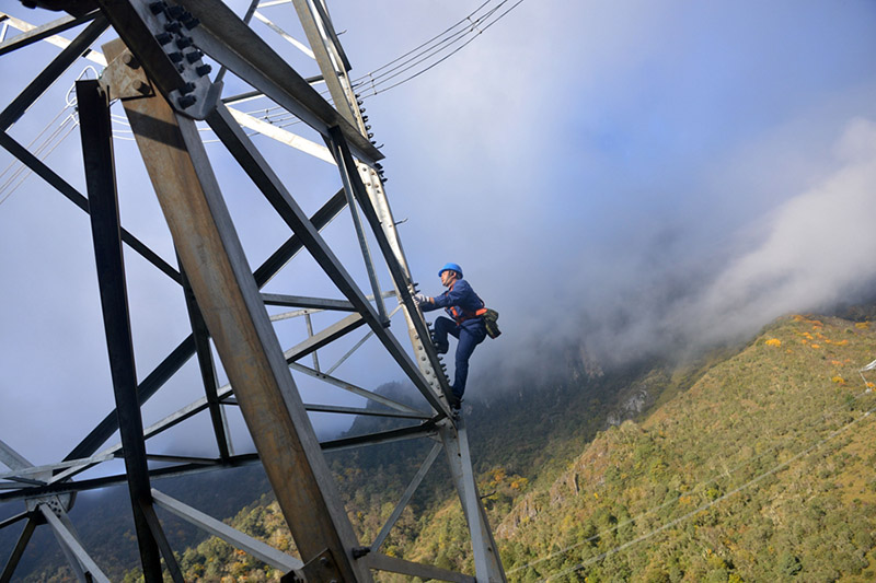El reparador Deng Yingfei sube a una torre de energía para inspeccionar una línea de transmisión. SERVICIO DE NOTICIAS DE CHINA / ZHANG LANG