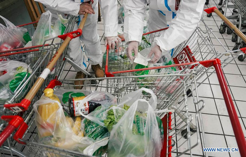 Voluntarios verifican pedidos de artículos de primera necesidad en un supermercado de acuerdo con las listas de deseos de los residentes en cuarentena en el distrito Dongchang de Tonghua, provincia de Jilin, noreste de China, el 24 de enero de 2021.