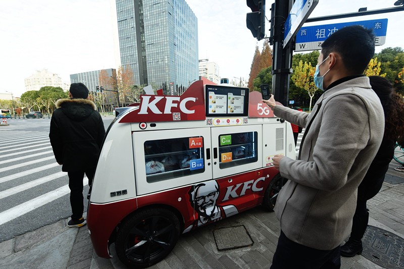 El 17 de diciembre de 2020, la gente escaneó el código de un vehículo inteligente de venta de desayunos 5G sin conductor para comprar un desayuno en Shanghai. (Long Wei / Pueblo en Línea)
