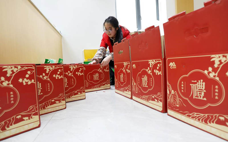 Una empleada de un centro de servicios públicos de comercio electrónico en el condado Cengong, prefectura autónoma Dong y Miao de Qiandongnan, en la provincia de Guizhou, en el suroeste de China, empaqueta regalos del Año Nuevo Chino, el 26 de enero de 2021 (Pueblo en Línea / Tang Peng).