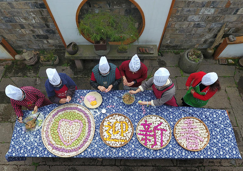 Aldea de Tantou, condado de Wuyi, Zhejiang, detallan las palabras "Saludos de Año Nuevo" con coloridas albóndigas de taro, 1 de febrero del 2021.  [Foto: Zhang Jiancheng/ China Daily]