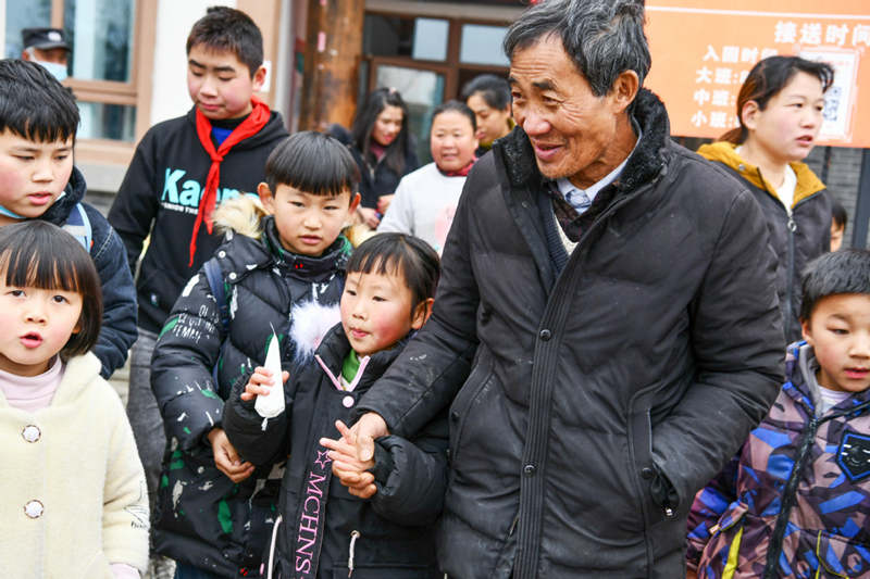 Li Changde recoge a sus nietos de la escuela en el condado Dafang, provincia de Guizhou, 23 de diciembre del 2020.