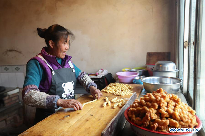 El aldeano Chen Jin'e prepara Mahua, un aperitivo de masa retorcida frita, antes del Año Nuevo Chino en la aldea Yuangudui del condado Weiyuan, en Dingxi, provincia de Gansu, noroeste de China, el 6 de febrero de 2021. [Foto / Xinhua]