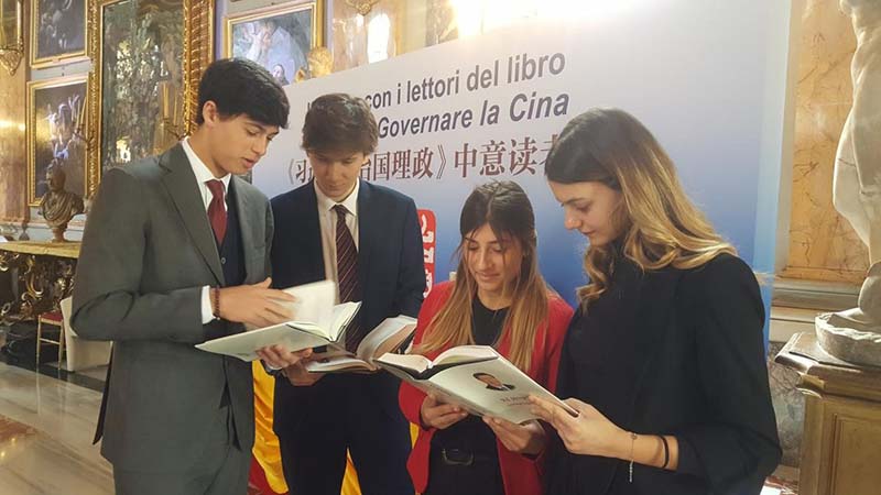 En Roma, Italia, cuatro estudiantes italianos observan la versión en italiano de "Xi Jinping: La gobernanza y administración de China". Por Ye Qi, Diario del Pueblo.