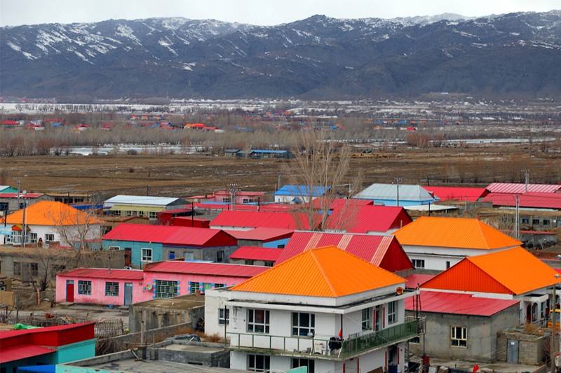 Pintoresca vista formada por coloridos edificios residenciales y montañas cubiertas de nieve en el condado de Burqin, Altay, Región Autónoma de Xinjiang Uygur, 26 de marzo del 2021. (Foto: Pueblo en Línea/Wang Jianfeng)