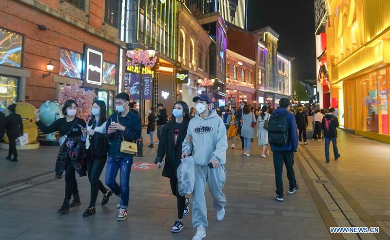 La gente camina en una calle comercial en Wuhan, provincia de Hubei, en el centro de China, el 28 de marzo de 2021.