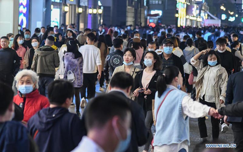La gente camina en una calle comercial en Wuhan, provincia de Hubei, en el centro de China, el 29 de marzo de 2021. 