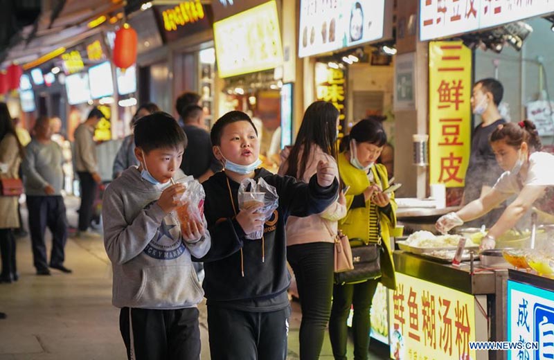 La gente come aperitivos en un callejón en Wuhan, provincia de Hubei, en el centro de China, el 28 de marzo de 2021. 