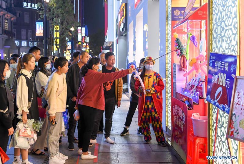 La gente se divierte en una calle comercial en Wuhan, provincia de Hubei, en el centro de China, el 29 de marzo de 2021.
