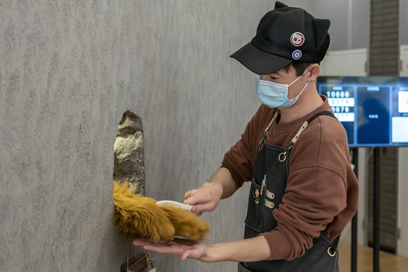 A Ken y la emblemática pata de oso del Café Hinichijou de Shanghai. [Foto: Xinhua]