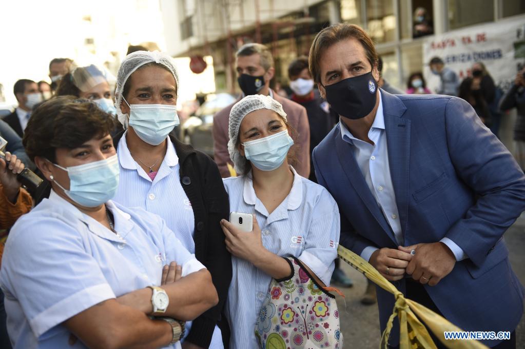 El presidente uruguayo, Luis Lacalle Pou (d), posa para una fotografía junto a trabajadoras de la salud después de recibir la segunda dosis de la vacuna CoronaVac desarrollada por la farmacéutica china Sinovac contra la enfermedad del nuevo coronavirus (COVID-19), en el hospital público Maciel, en Montevideo, capital de Uruguay, el 26 de abril de 2021. Lacalle Pou recibió el lunes la segunda dosis de la vacuna CoronaVac desarrollada por la farmacéutica china Sinovac contra la COVID-19. (Xinhua/Nicolás Celaya)      