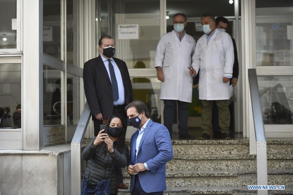 El presidente uruguayo, Luis Lacalle Pou (d-frente), posa para una fotografía junto a una mujer después de recibir la segunda dosis de la vacuna CoronaVac desarrollada por la farmacéutica china Sinovac contra la enfermedad del nuevo coronavirus (COVID-19), en el hospital público Maciel, en Montevideo, capital de Uruguay, el 26 de abril de 2021. Lacalle Pou recibió el lunes la segunda dosis de la vacuna CoronaVac desarrollada por la farmacéutica china Sinovac contra la COVID-19. (Xinhua/Nicolás Celaya)