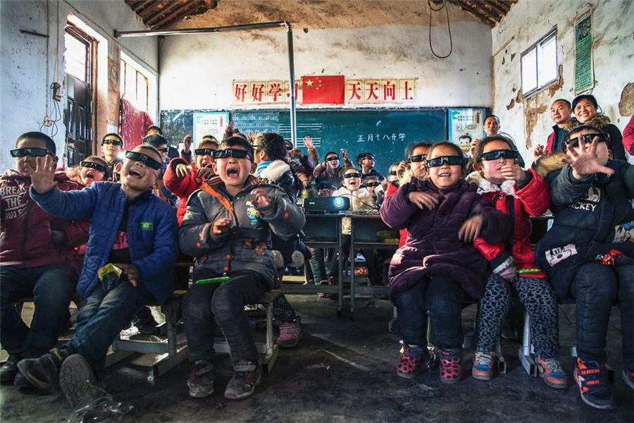 Niños ven una película de animación en 3D transmitida por voluntarios en una escuela primaria de Miaokou, condado de Qi, provincia de Henan, 2 de febrero del 2018. [Foto: Zhang Zhaozeng/cpanet.org.cn]