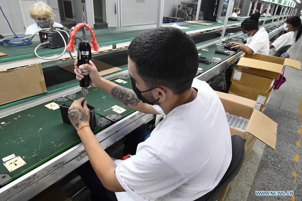 Imagen del 21 de mayo de 2021 de trabajadores ensamblando cajas decodificadoras usadas para la televisión digital con norma china en los talleres de la Empresa Industria Electrónica "Comandante Camilo Cienfuegos", en La Habana, capital de Cuba. Cuba espera dar un impulso a la expansión de la televisión digital con norma china mediante la producción este año de 318.000 cajas decodificadoras, en el contexto de la pandemia de la enfermedad del nuevo coronavirus (COVID-19) y los efectos de las sanciones económicas del bloqueo de Estados Unidos contra el país. (Xinhua/Joaquín Hernández)