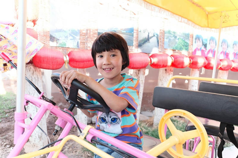 Una niña monta un triciclo de juguete en Kashgar, en la región autónoma Uygur de Xinjiang, en el noroeste de China, el 19 de mayo de 2021 (Pueblo en Línea / Kou Jie).