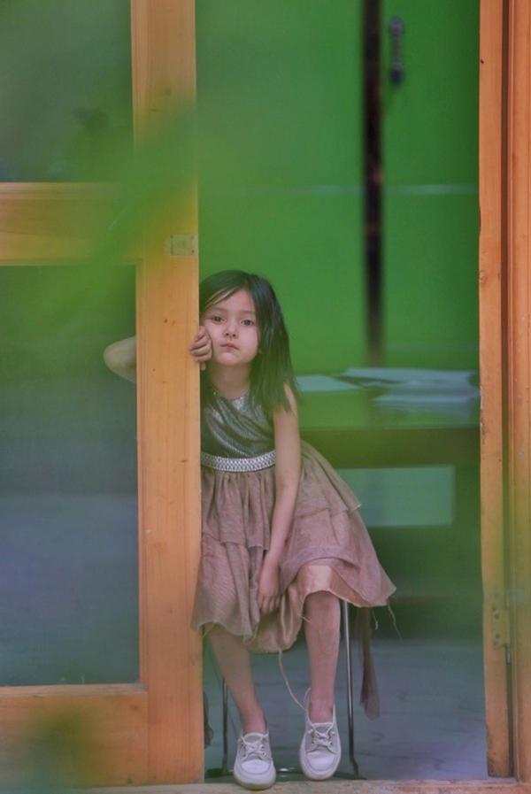 Una niña Uygur sentada frente a su casa en Tuancheng, la calle peatonal más famosa en la ciudad de Hotan, en la región autónoma Uygur de Xinjiang, en el noroeste de China, el 22 de mayo de 2021 (Pueblo en Línea / Yuan Meng).