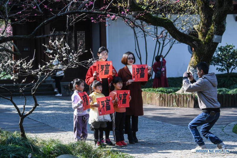 Turistas se hacen una foto en grupo bajo los ciruelos en el área escénica de la montaña Chaoshan en el distrito Yuhang de Hangzhou, provincia de Zhejiang, en el este de China, el 7 de febrero de 2021. [Foto / Xinhua]