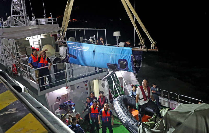 Rescatistas mueven una ballena cabeza de melón antes de devolverla al océano en Taizhou, provincia de Zhejiang, 7 de julio del 2021. [Foto: Pan Kanjun/ China Daily]