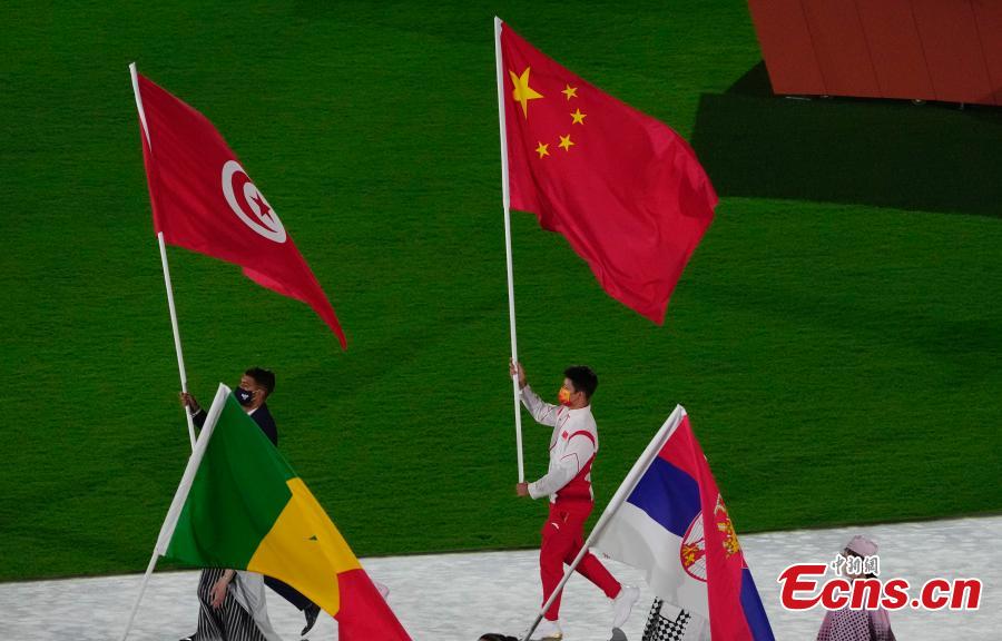 El velocista chino Su Bingtian camina por el Estadio Olímpico con la bandera nacional de China durante la ceremonia de clausura de los Juegos Olímpicos de Tokio 2020 en Japón, el 8 de agosto de 2021 (Foto: China News Service / Du Yang).