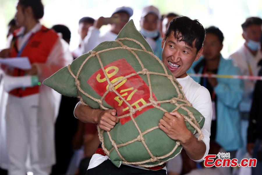 Un competidor levanta una bolsa de arena durante la competición en los séptimos Juegos Deportivos de Minorías Étnicas Tradicionales de Qinghai en la ciudad de Haidong, provincia de Qinghai, noroeste de China, el 13 de septiembre de 2021 (Foto: Servicio de Noticias de China / Zhang Tianfu)