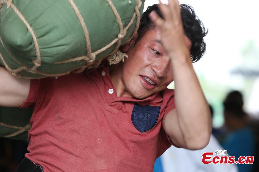 Un competidor levanta una bolsa de arena durante la competición en los séptimos Juegos Deportivos de Minorías Étnicas Tradicionales de Qinghai en la ciudad de Haidong, provincia de Qinghai, noroeste de China, el 13 de septiembre de 2021 (Foto: Servicio de Noticias de China / Zhang Tianfu)