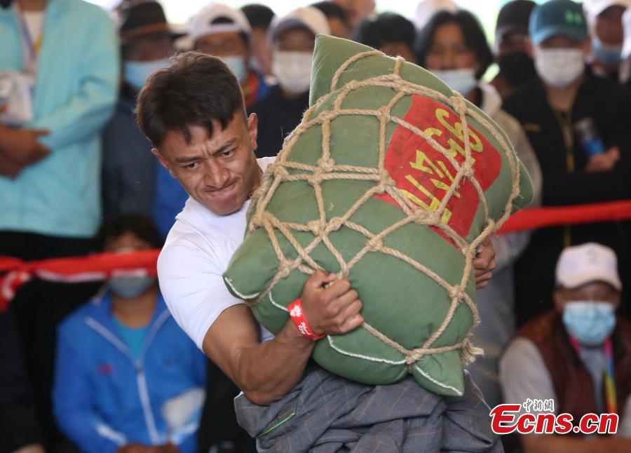 Un competidor levanta una bolsa de arena durante la competición en los séptimos Juegos Deportivos de Minorías Étnicas Tradicionales de Qinghai en la ciudad de Haidong, provincia de Qinghai, noroeste de China, el 13 de septiembre de 2021 (Foto: Servicio de Noticias de China / Zhang Tianfu)