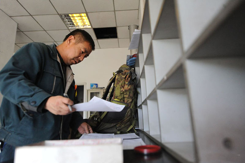 Wang Shouqiu clasifica el correo en la oficina de correos. [Foto proporcionada a chinadaily.com.cn]