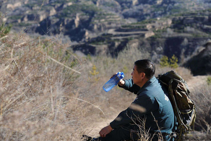 Wang Shouqiu descansa mientras entrega el correo en las zonas montañosas del distrito Wanbailin en Taiyuan, provincia de Shanxi. [Foto proporcionada a chinadaily.com.cn]