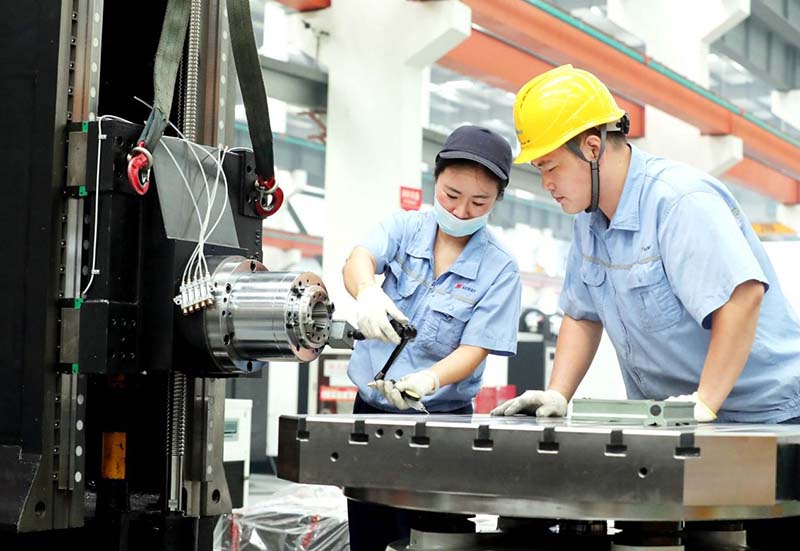 La foto tomada el 26 de agosto del 2021 muestra a los empleados de Neway CNC Equipment (Suzhou) Co., Ltd. con sede en la zona de desarrollo industrial de alta tecnología de la ciudad de Suzhou, provincia de Jiangsu, ensamblando máquinas de control numérico en un taller. (Foto: Hua Xuegen/ Pueblo en Línea)