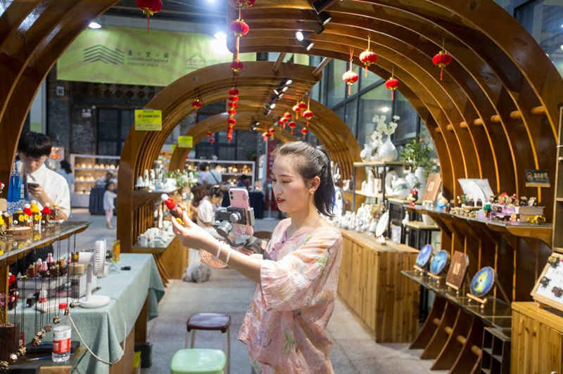 En el Mercado Nocturno de Cerámica Creativa del Distrito Cultural y Creativo de Taoxichuan en Jingdezhen, provincia de Jiangxi, una presentadora muestra mediante transmisión en vivo los productos. Zhai Huiyong / Pueblo en Línea