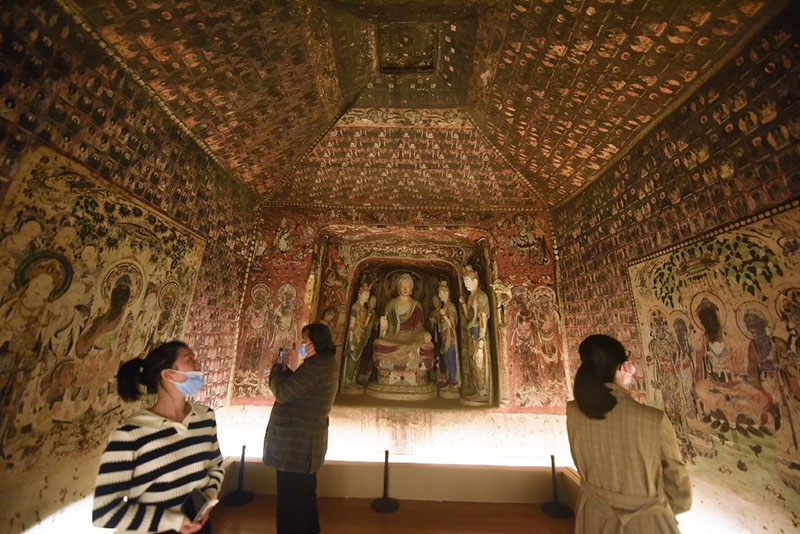 Los visitantes ven una réplica impresa en 3D de la Cueva 57 de las Grutas de Mogao, un sitio de renombre que contiene arte budista en Dunhuang, provincia de Gansu, en el Museo de Arte y Arqueología de la Universidad de Zhejiang en Hangzhou, provincia de Zhejiang, el 2 de noviembre de 2021. (Pueblo en Línea / Long Wei).