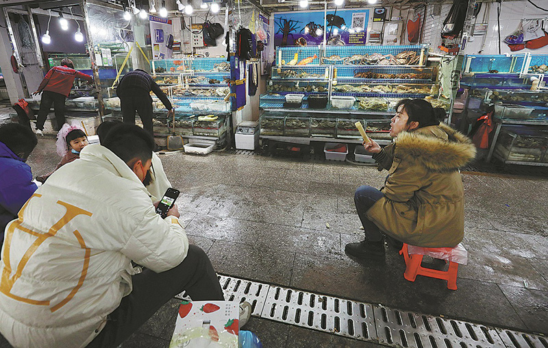 Los pequeños minoristas esperan a los clientes en el Mercado Jingshen de Productos del Mar, 19 de noviembre. (Foto: Zhu Xingxin/ China Daily)
