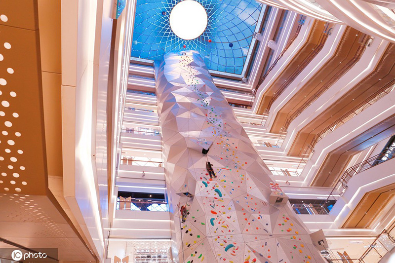 Los entusiastas de los deportes extremos experimentan la escalada en roca en un centro comercial de Shanghai, 19 de diciembre del 2021. [Foto: IC]