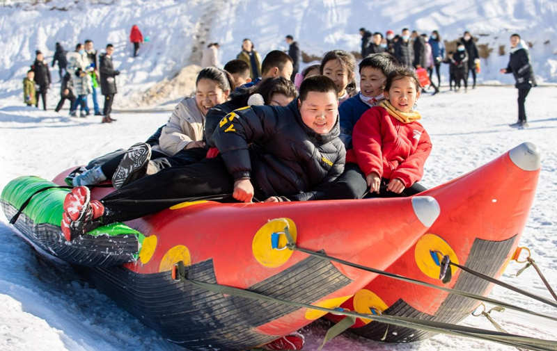 El 19 de diciembre de 2021, los niños se divierten en unos plátanos inflables en la nieve en el Parque de Hielo y Nieve de la Aldea Dakulun, en Hohhot, región autónoma de Mongolia Interior. Ding Genhou / Pueblo en Línea