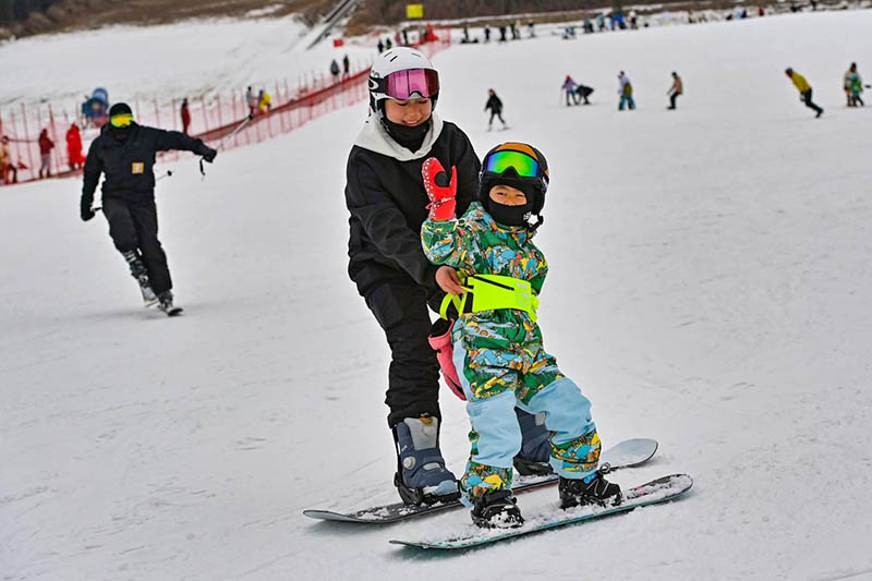 Los niños practican esquí con la ayuda de sus familias en la estación de esquí de Tuoshan en la ciudad de Qingzhou, provincia de Shandong, el 5 de enero de 2022. Wang Jilin/Pueblo en Línea