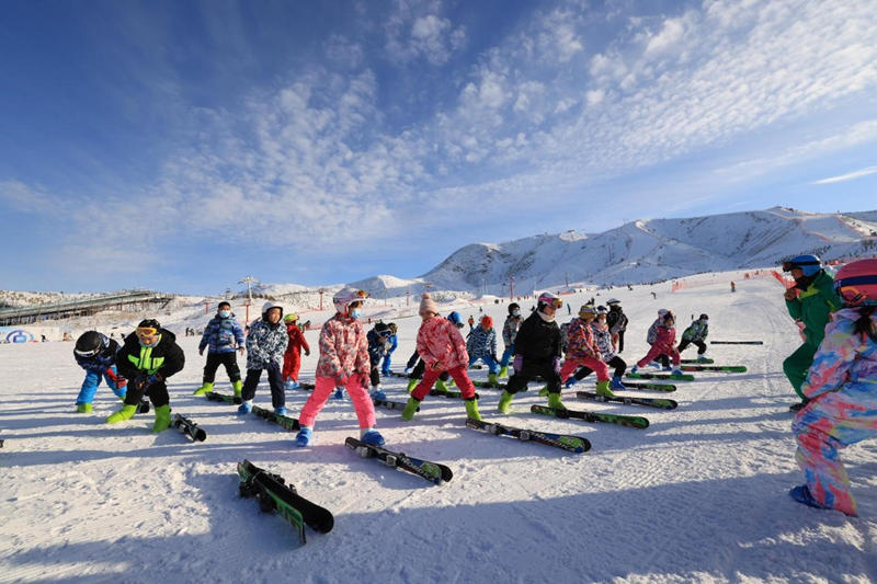 Estudiantes de una escuela primaria practican habilidades de esquí en una estación de esquí en la ciudad de Altay, en la región autónoma Uygur de Xinjiang, en el noroeste de China, el 6 de enero de 2022. (Foto de Aldark/Pueblo en Línea)