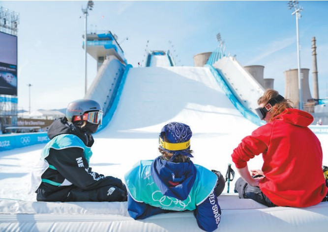 El 6 de febrero de 2022, en la plataforma de salto de esquí de Shougang, tres atletas descansaron juntos después de completar su entrenamiento de salto de esquí de estilo libre. Foto por Li Ge, Diario del Pueblo.