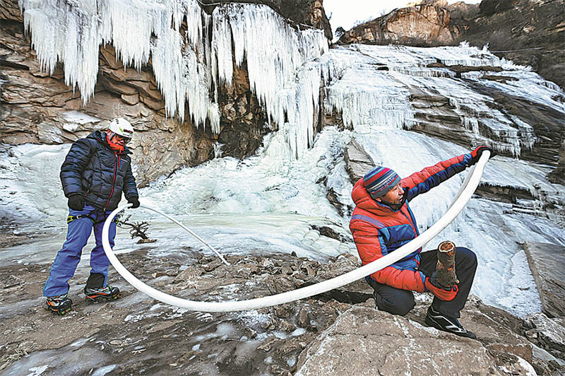 Yu Kaiyi (a la derecha) y un colega ayudan a mantener las formaciones de hielo en Yunmeng, 17 de diciembre del 2021. (Foto: Wei Xiaohao/ China Daily)