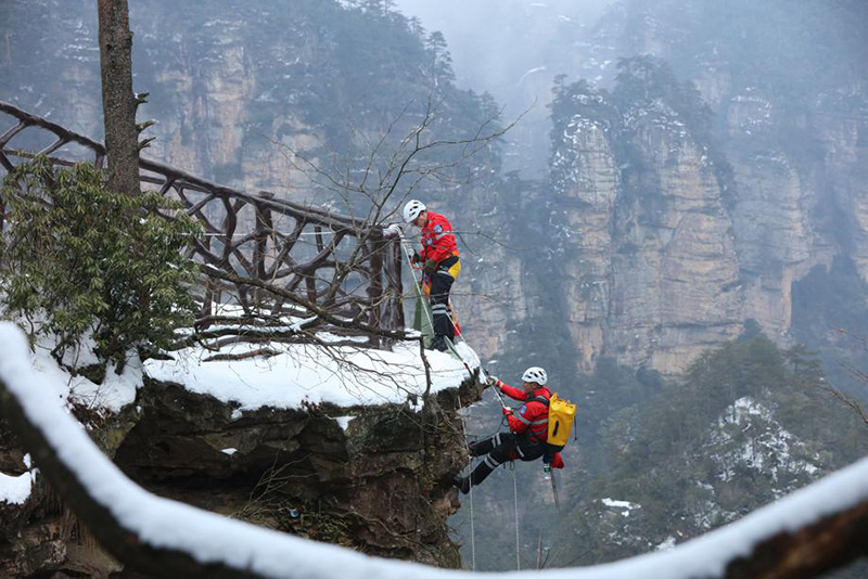 Durante una sesión de entrenamiento, miembros del equipo de rescate de emergencia se ofrecieron como voluntarios para recoger basura en rocas y acantilados del sitio turístico Wulingyuan de Zhangjiajie, provincia de Hunan, febrero del 2022. [Foto: Wu Yongbing/ China Daily]