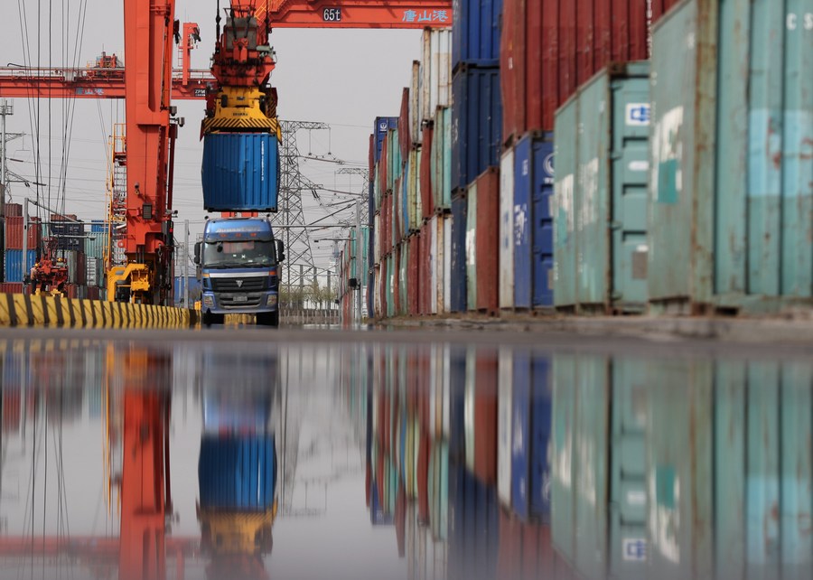 Un camión carga contenedores en el puerto de Tangshan, provincia de Hebei, 16 de abril del 2021. [Foto: Xinhua]