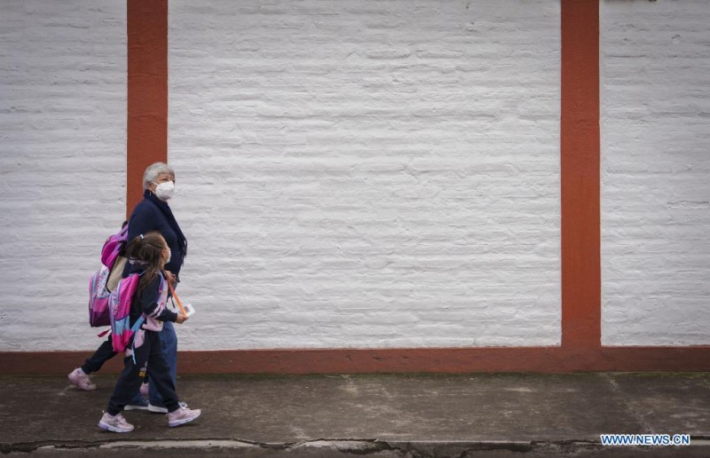 QUITO, 14 marzo, 2022 (Xinhua) -- Una mujer camina con sus nietas por una calle luego de clases presenciales, en Quito, capital de Ecuador, el 14 de marzo de 2022. Los estudiantes ecuatorianos volvieron el lunes en su totalidad a las clases presenciales sin restricciones de aforo y en todos los niveles de educación tras dos años de pandemia del nuevo coronavirus (COVID-19) en el país. (Xinhua/Santiago Armas)