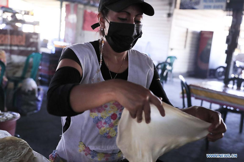 Una mujer elabora tortillas de harina en un mercado, en Tegucigalpa, Honduras, el 18 de marzo de 2022. (Xinhua/Rafael Ochoa)