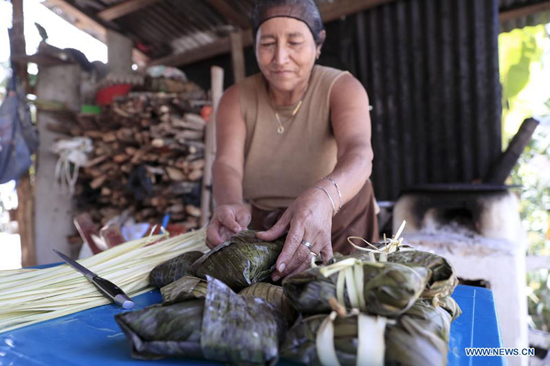 Una mujer prepara tamales en su casa para su venta, en la aldea El Chimbo, en el municipio de Santa Lucía, en el departamento de Francisco Morazán, Honduras, el 18 de marzo de 2022. (Xinhua/Rafael Ochoa)