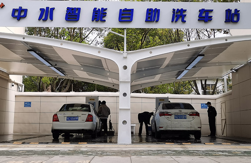Los residentes prueban el servicio de lavado de coches de autoservicio en una estación en Wuhan, el 23 de marzo de 2022. [Foto/IC]