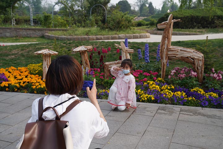Una niña posa frente a unas flores en el Jardín Botánico Nacional, Beijing, 25 de abril del 2022. (Foto: Pueblo en Línea/ Zhang Wenjie)