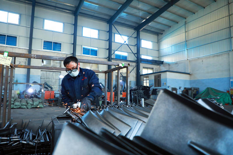 Un trabajador pule palas de acero en un taller de Tangshan Renhe Hardware Tool, en el condado de Luannan de Tangshan, provincia de Hebei. [Foto: Liu Lanwei/ chinadaily.com.cn]