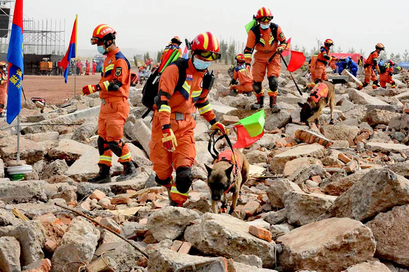 Trabajadores de rescate y perros realizan simulacros de búsqueda y rescate en el campo de entrenamiento de la ciudad de Zhangye, provincia de Gansu, 11 de mayo del 2022. [Foto: Pei Qiang/ China Daily]