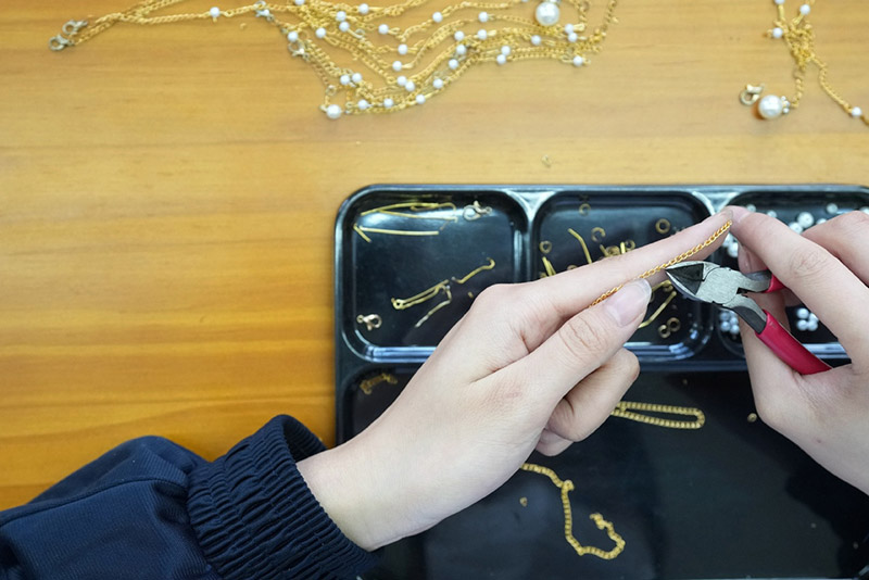 Una estudiante con discapacidad auditiva practica la fabricación de joyas en la Escuela de Economía Urbana de Shaanxi, provincia de Shaanxi, 13 de mayo del 2022. [Foto: Xinhua]