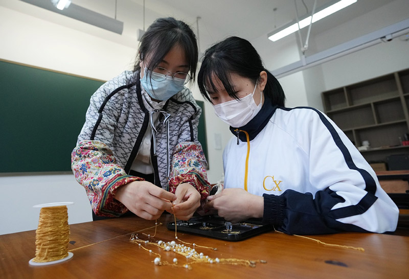 Una estudiante con discapacidad auditiva aprende a hacer joyas en la Escuela de Economía Urbana de Shaanxi, provincia de Shaanxi, 13 de mayo del 2022. [Foto: Xinhua]