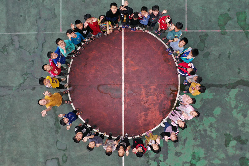 El 26 de mayo de 2022, los niños de la escuela primaria Yudong se tomaron una foto grupal en la cancha de baloncesto (foto de un dron).